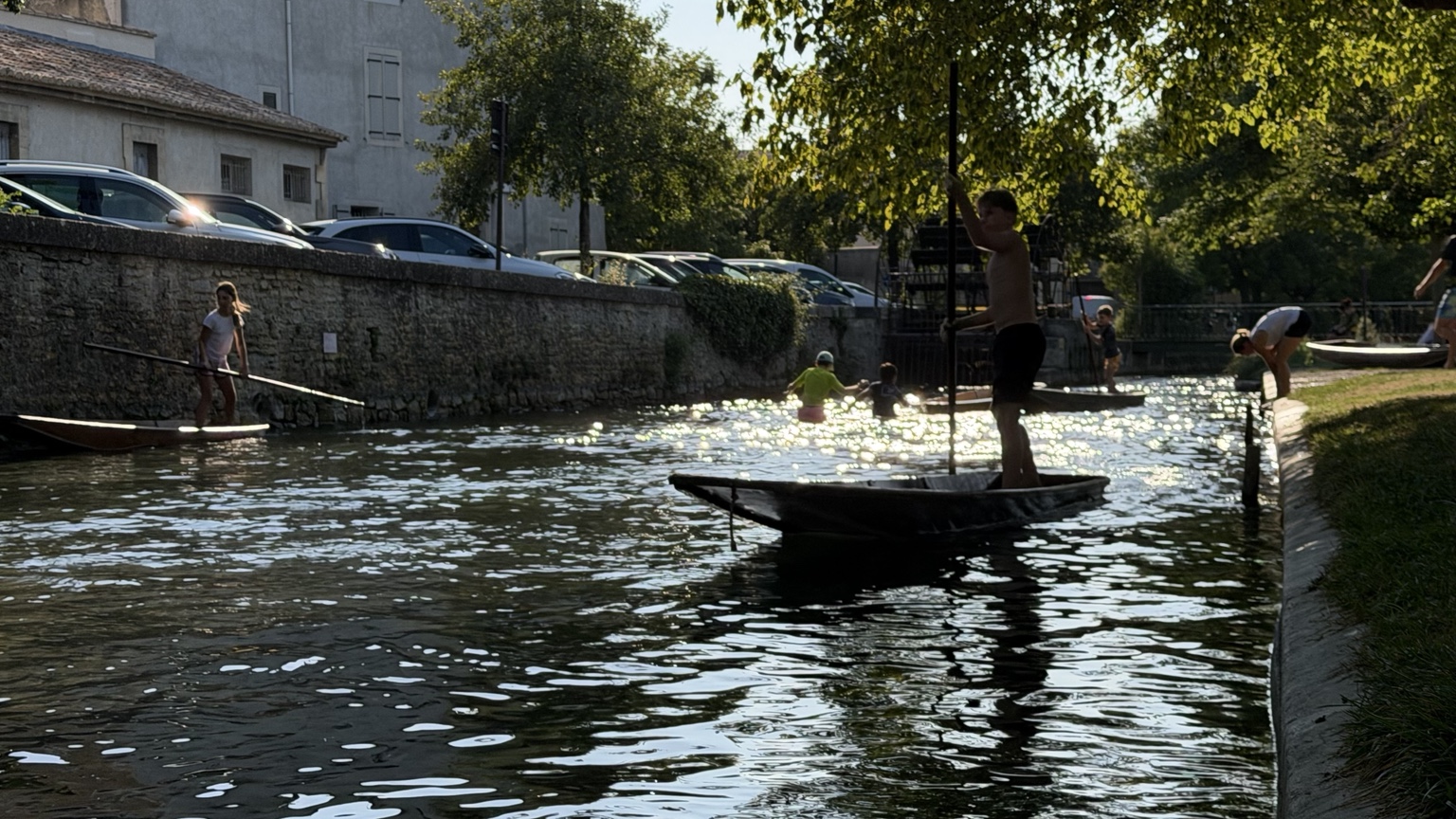 Kinderen varen met platte bootjes op de Sorgue