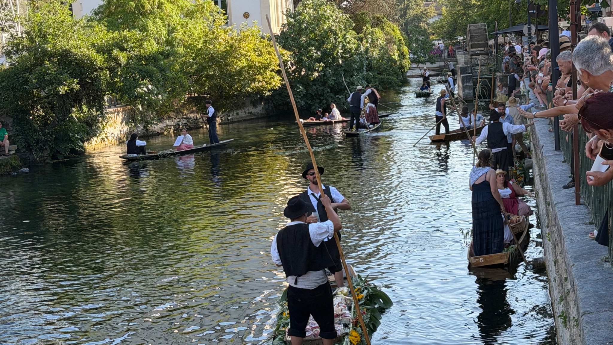Traditionele boten varen tussen het publiek langs de kade