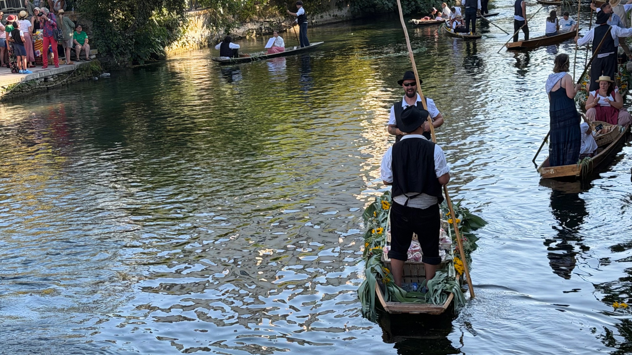 Versierde platte boten op het glinsterende water van de Sorgue
