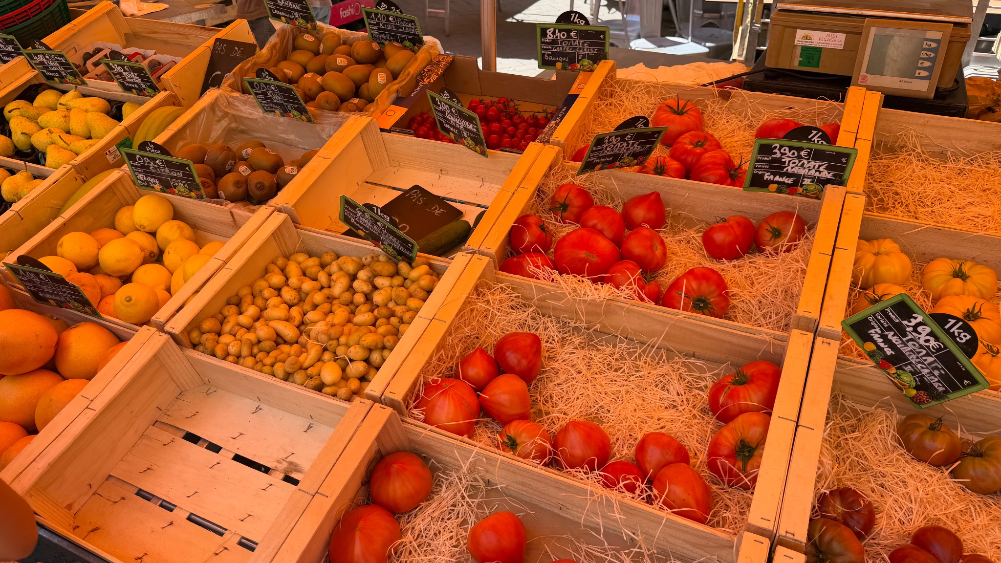 Kisten met tomaten, citrusvruchten, aardappelen en ander vers marktwaar