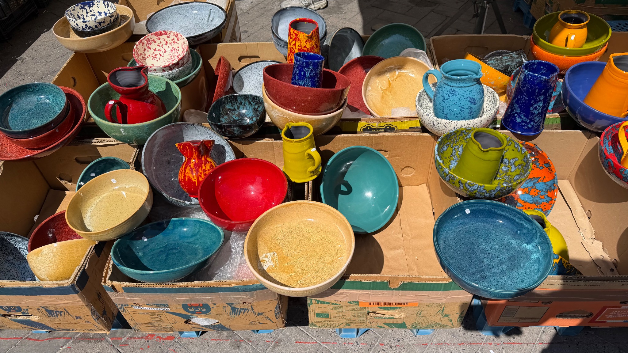 Kleurrijke handgemaakte schalen en kannen van keramiek op de zondagmarkt